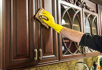 Image showing someone cleaning wood upper cabinet doors