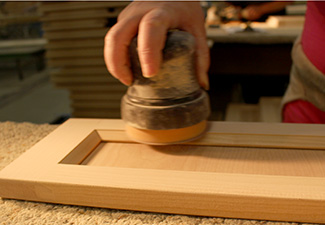 Image showing close up of palm sander being used on a cabinet door