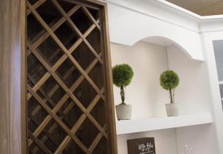 Image of upper cabinet showing custom Walnut stained wine rack, white painted floating shelves and valance